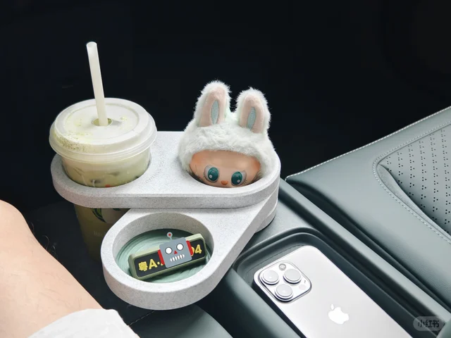 浅色杯架装在车内，放着饮品与小摆件